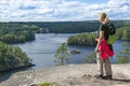 Woman hiking in forest and looking lake view in Finlande on a sunny summer day in Finland