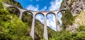 Landscape with Landwasser Viaduct in summer, Filisur, Switzerland. Panoramic view of high railroad bridge and red train