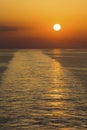 Landscape of a large boat wake on ocean at sunset