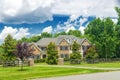 Landscape with large country house. Large mowed lawn and blue sky