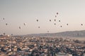 Landscape with a lot of hot air balloons in the sky over the city. Famous Turkish region Cappadocia with mountains and Royalty Free Stock Photo