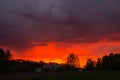 Landscape with majestic colorful dramatic red sky with fluffy clouds at sunset before before a thunderstorm and rain Royalty Free Stock Photo