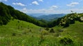 Landscape with meadow, wooden houses with thatched roof and mountains Royalty Free Stock Photo