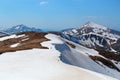 The landscape with the meadows, high mountains and peaks covered with snow. A man in shorts is staying at the edge of the chasm. Royalty Free Stock Photo