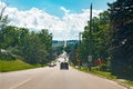 landscape midday view of Canadian Ontario country side road with cars traffic during sunny day with white clouds in blue sky. Royalty Free Stock Photo