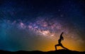 Landscape with Milky way galaxy. Night sky with stars and silhouette woman practicing yoga on the mountain. Royalty Free Stock Photo