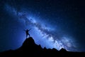 Landscape with Milky Way and silhouette of a happy climber