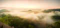 Landscape misty panorama. Fantastic dreamy sunrise above fairy misty valley