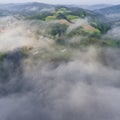 Landscape misty panorama. Fantastic dreamy sunrise on rocky mountains with view into misty valley below. Foggy clouds above Royalty Free Stock Photo