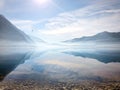 Landscape morning fog, mountains reflected in calm water, seagulls fly Royalty Free Stock Photo