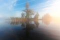 Landscape of morning nature on lake with blue sky, clouds, fog mist and lonely tiny island with trees Royalty Free Stock Photo