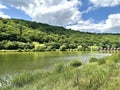 Landscape of mountain lake and hills with green forest and wooden houses Royalty Free Stock Photo