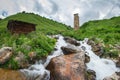 Landscape of a mountain stream in the village of Adishi, Svaneti, Georgia with a Svan ancient tower on a hill