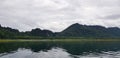 Landscape of mountain view with river or lake, white sky and Reflection on water at Srinakarin dam Royalty Free Stock Photo