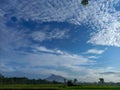 landscape of mountain views, cloudy skies, and green expanses of rice fields Royalty Free Stock Photo