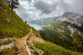 landscape with mountains, Fedaia lake, clouds, forest and trail Royalty Free Stock Photo