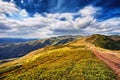 Landscape mountains and field of green fresh grass under blue sk Royalty Free Stock Photo