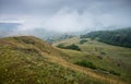 Landscape with mountains and fields with flowers on a cloudy summer day after rain with a haze Royalty Free Stock Photo