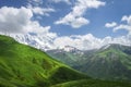 Landscape of mountains and grassy hills on sunny summer day in Svaneti, Georgia. Blue sky and white clouds over georgian mountain