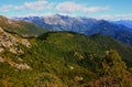 Landscape with mountains and green hills in the foreground against a blue sky with clouds on Mount Cimetta, in Switzerland Royalty Free Stock Photo