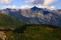 Landscape with mountains and green hills in the foreground against a blue sky with clouds on Mount Cimetta, in Switzerland Royalty Free Stock Photo