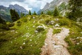 landscape with mountains, hills, clouds, rocks, trees and trail