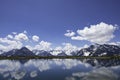 Landscape with mountains, lake, clouds, grass land and tourists Royalty Free Stock Photo