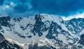 Landscape with the mountains in snow and heavy clouds in the background Royalty Free Stock Photo