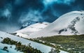 Landscape with the mountains in snow and heavy clouds in the background Royalty Free Stock Photo