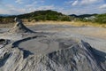 Landscape with mud volcanos with small eruptions and mountains Royalty Free Stock Photo