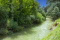 Landscape, narrow mountain river with emerald water surrounded by trees