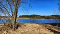 Landscape and nature with calm water of big lake, trees on the shore and blue sky on autumn or spring sunny day. Sun and Royalty Free Stock Photo