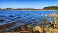 Landscape and nature with calm water of big lake, trees on the shore and blue sky on autumn or spring sunny day. Sun and Royalty Free Stock Photo