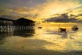 Landscape nature sunrise scenery of seacoast,wooden house and fisherman on the boat at Nagalang beach,Labuan,Malaysia. Royalty Free Stock Photo