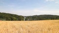 Landscape of oat field and Ostrzyckie lake, Wiezyca, Kashubian Region, Poland Royalty Free Stock Photo