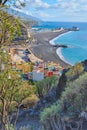 Landscape of an ocean coast with black beach sand on Puerto de Tazacorte. Colorful town houses or holiday resort Royalty Free Stock Photo