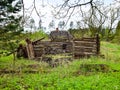 Old and collapsed country house, collapsed wall and old wooden logs