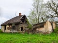 Old and collapsed country house, collapsed wall and old wooden logs