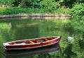 Landscape with old row boat and swan on lake in forest in summer Royalty Free Stock Photo