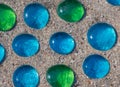 White, blue and green glass beads on sand Royalty Free Stock Photo