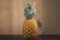 Landscape orientation picture of a Ripe Tropical Pinapple on a wooden table with a wooden background. Royalty Free Stock Photo