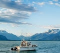Landscape over lake geneva dents du midi and swiss alps with a fishing boat as firstground Royalty Free Stock Photo