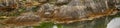 Landscape panorama of a hill and lake in arctic circle in Norway. Scenic view of water washing around boulders and rocks Royalty Free Stock Photo