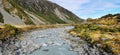 Landscape panorama image of a glacier fed river running through a mountain valley with alpine vegetation Royalty Free Stock Photo