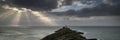 Landscape panorama of Mumbles lighthouse in Wales with sunbeams Royalty Free Stock Photo