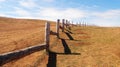 Landscape of pasture for cattle, wooden fence in prairie, blue sky with clouds. Royalty Free Stock Photo