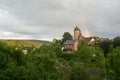 Landscape photo of Muerlenbach in the Eifel in summer with a rainbow and Bertrada Castle