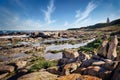 A landscape photo of a rocky coast during low tide.