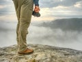 Landscape photograper with camera ready in hand. Man climbed up