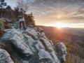 Landscape photograper with hand on camera and tripod